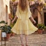 Woman wearing Elara Butter Yellow Cotton Flared Midi Dress by Jivaraa