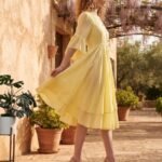 Woman wearing Elara Butter Yellow Cotton Flared Midi Dress by Jivaraa