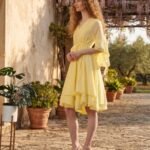 Woman wearing Elara Butter Yellow Cotton Flared Midi Dress by Jivaraa